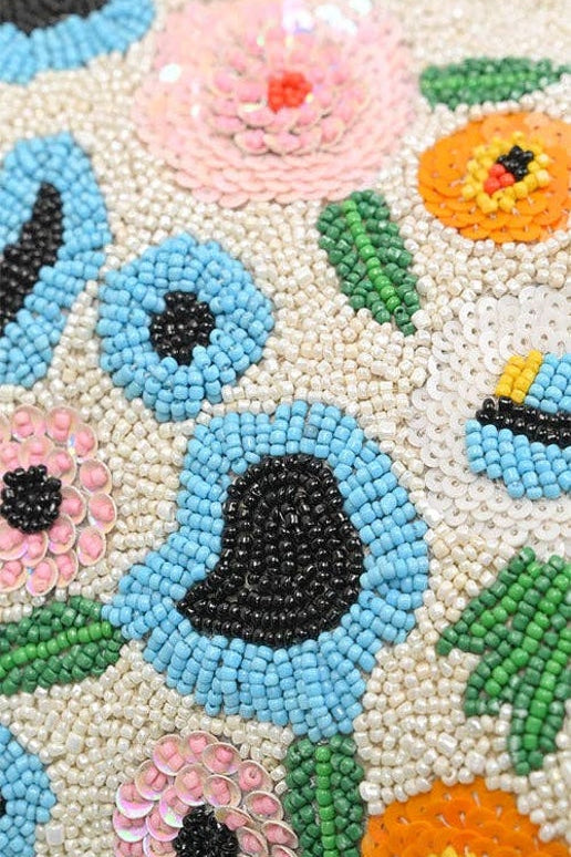 Close-up of a beaded fabric with floral patterns in various colors.